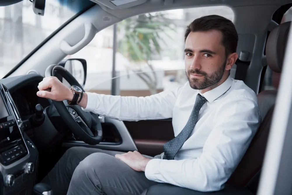 Chauffeur in a shirt and tie at the wheel