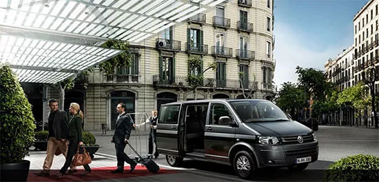 Chauffeur bringing luggage to a van outside a hotel